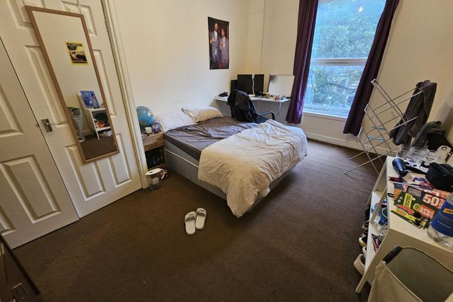 A Cozy Bedroom With A Large Window Providing Natur...