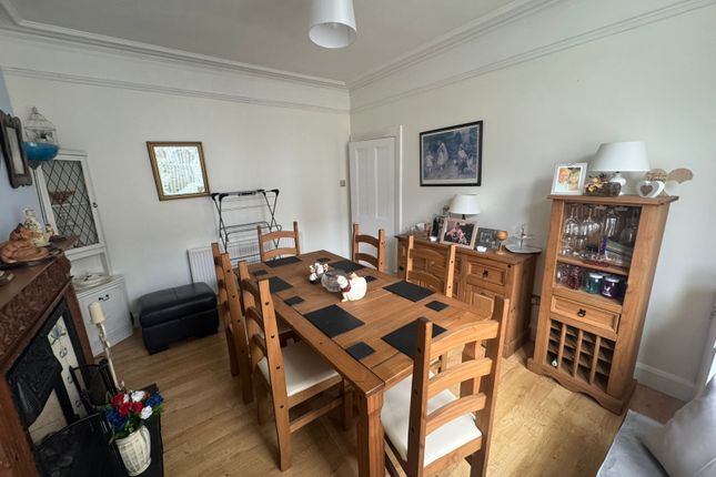 A Cozy Living Room Featuring A Wooden Dining Table...