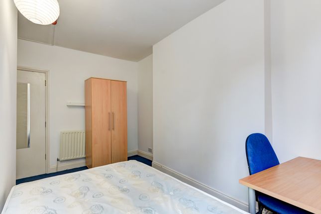 A Cozy Single Bedroom Featuring A Bed With A Simpl...