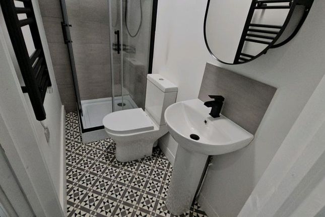 A Modern Bathroom Featuring A Stylish Patterned Fl...