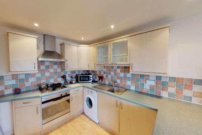 A Neat And Functional Kitchen Featuring Light Wood...