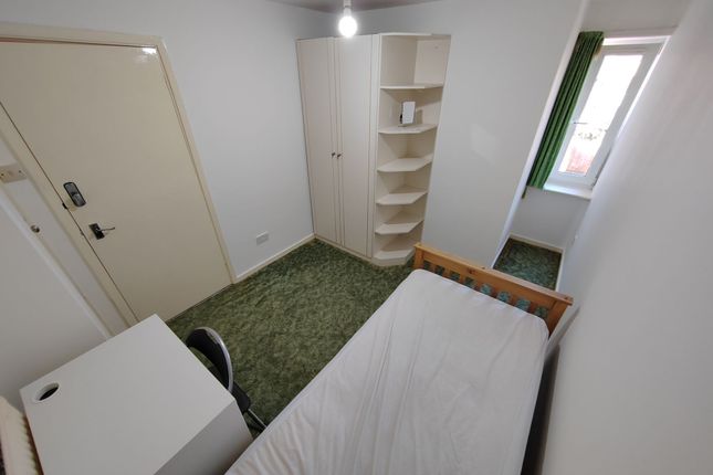 A Cozy Single Bedroom With A Simple Bed Frame, A W...