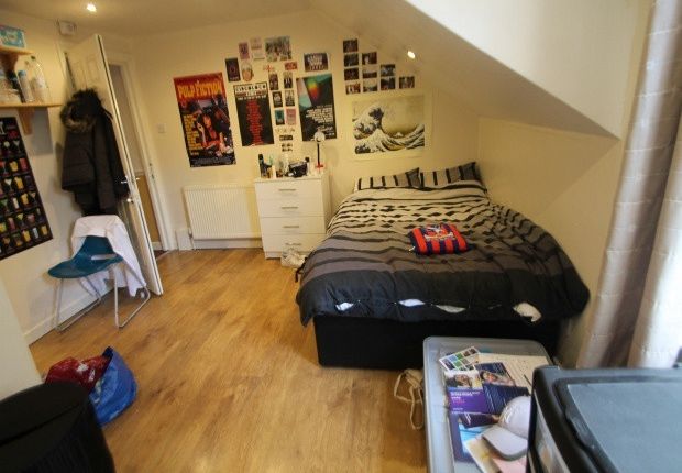 A Cozy Bedroom Featuring A Double Bed With A Bedsi...