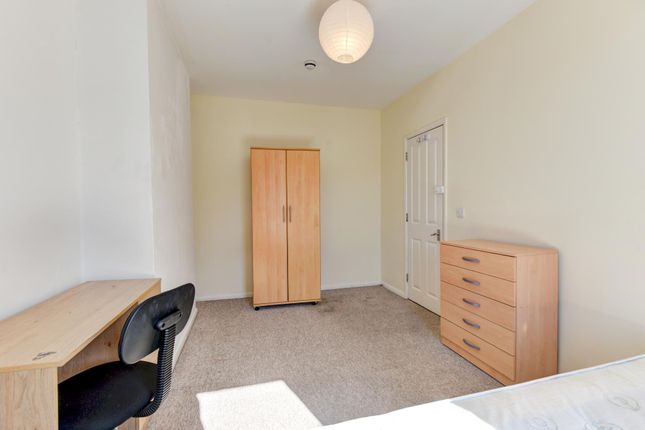 A Well-Lit Bedroom With A Desk, A Wardrobe, And A ...