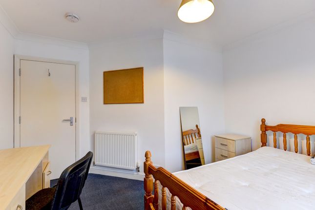 A Bright And Tidy Bedroom Featuring A Wooden Bed F...