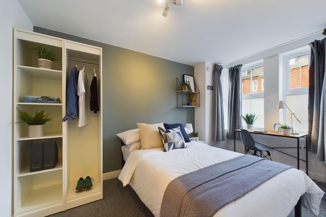 A Bright And Comfortable Bedroom Featuring A Neatl...