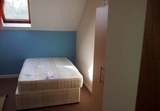 A Cozy Single Bedroom Featuring A Comfortable Bed ...