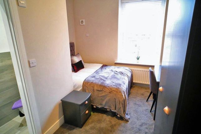 Cozy Single Bedroom Featuring A Neatly Made Bed, A...