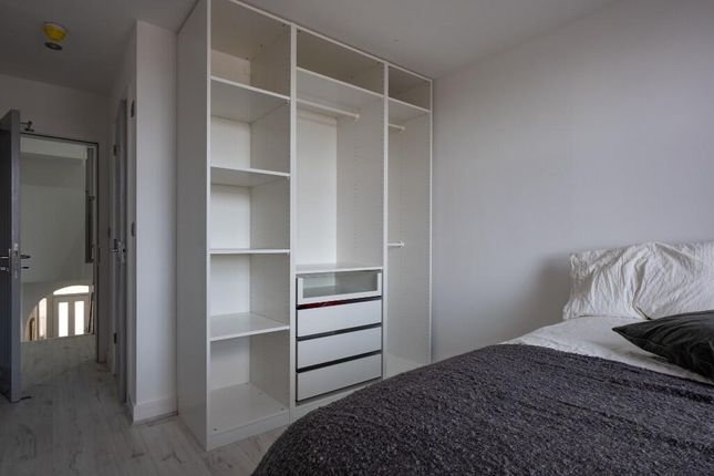 A Bright And Tidy Bedroom Featuring A Large Wardro...