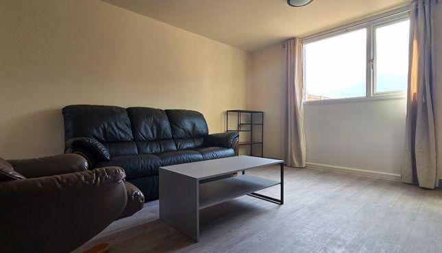 A Spacious And Well-Lit Living Room Featuring Comf...