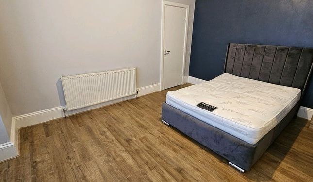 A Spacious Master Bedroom Featuring A Modern Dark ...