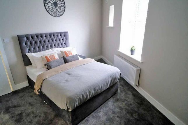 A Cozy Double Bedroom Featuring A Plush Grey Carpe...