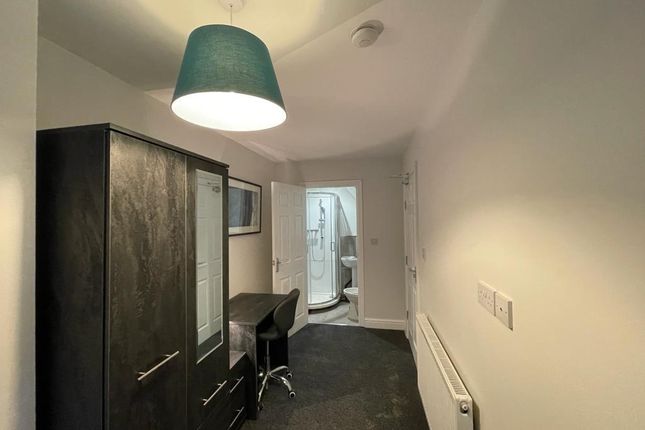 A Clean And Cozy Single Bedroom With A Dark Wardro...