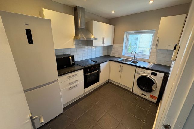 Modern Kitchen Featuring White Cabinetry, A Microw...