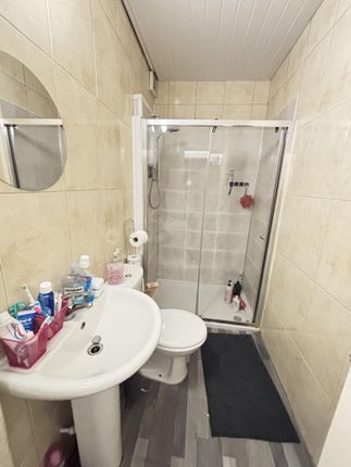 A Clean And Functional Bathroom With A Shower Encl...