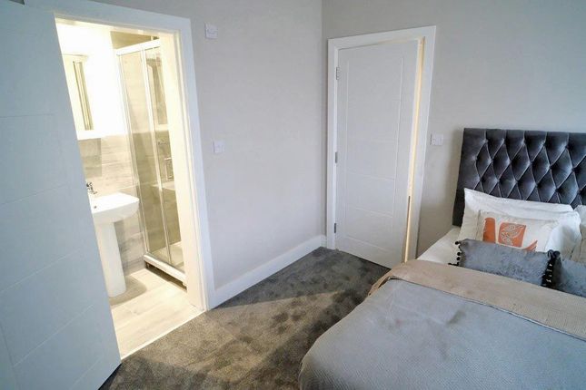 A Modern And Cozy Master Bedroom Featuring A Comfo...