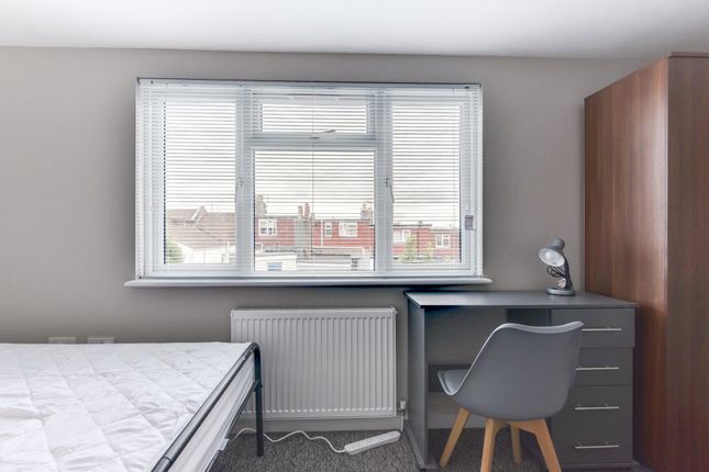 A Neatly Maintained Bedroom Featuring A Window Tha...