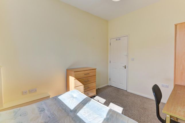 Bright And Tidy Bedroom Featuring A Large Window T...