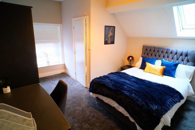 A Cozy Master Bedroom Featuring A Stylish Upholste...