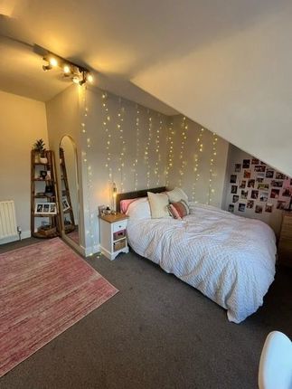 A Cozy Bedroom Featuring A Neatly Made Bed With Co...