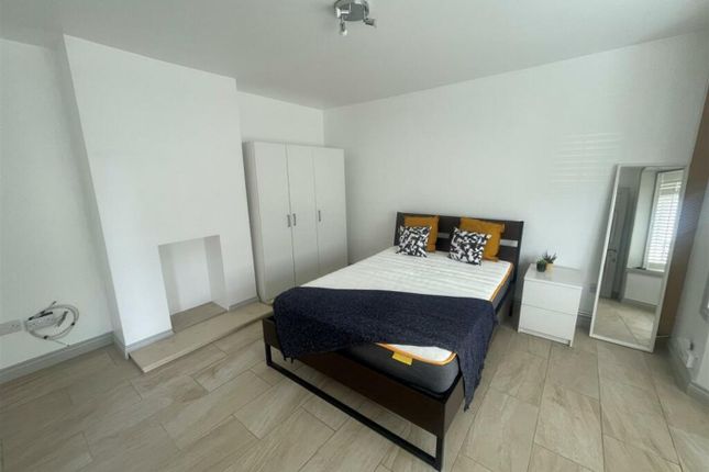 A Well-Lit Double Bedroom Featuring A Bed, Wardrob...