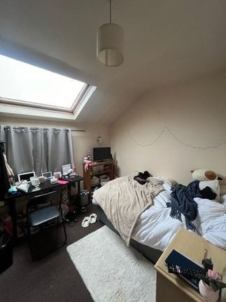 A Cozy Bedroom With A Sloped Ceiling Illuminated B...