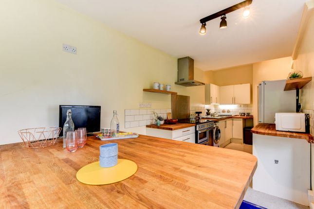 A Modern, Well-Lit Kitchen With Wooden Countertops...