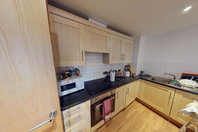 A Modern Kitchen Featuring Light Wood Cabinets And...