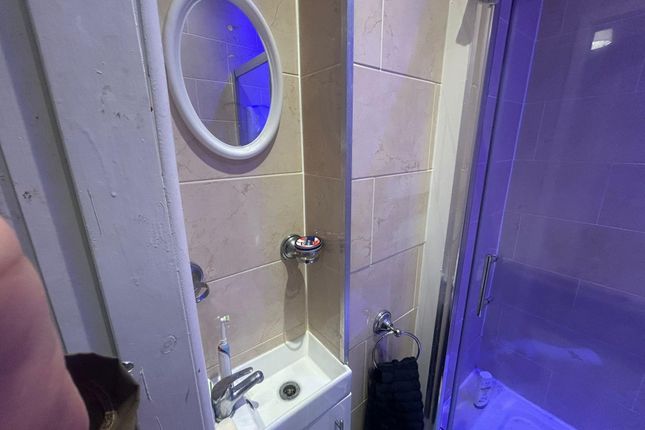 A Compact Bathroom Featuring A Small Sink, Mirror,...