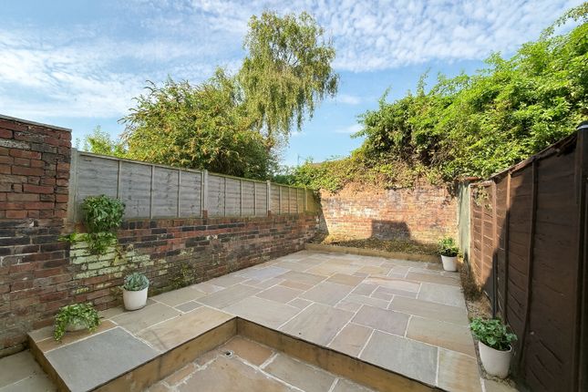 A Charming Private Garden With A Clean, Paved Pati...