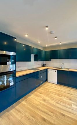 Modern Kitchen Featuring Sleek Dark Blue Cabinetry...