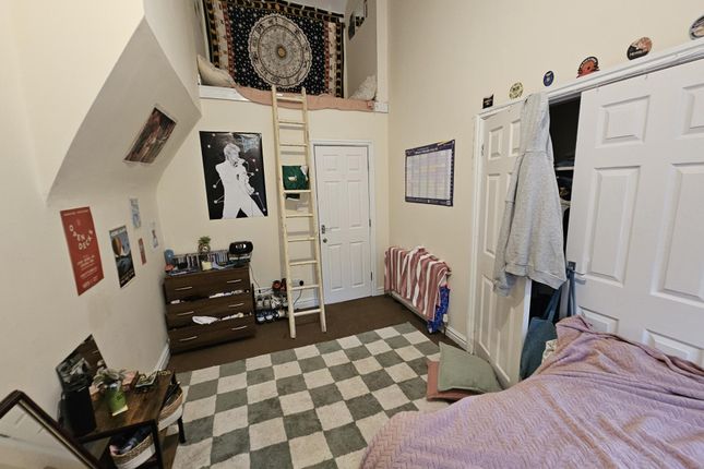 A Cozy Bedroom Featuring A Bed With A Pink Cover, ...