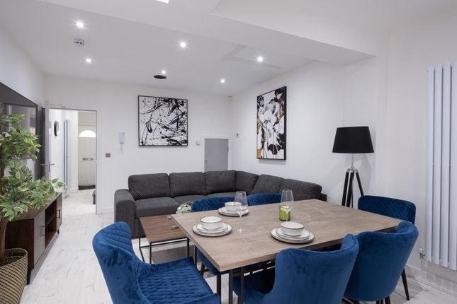 Spacious And Modern Living Room Featuring A Cozy S...