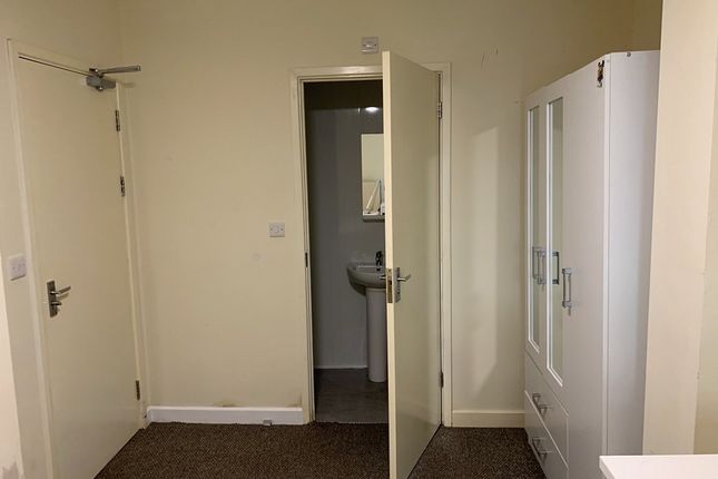 A Simple And Functional Room Featuring A Door Lead...