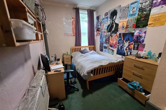 A Cozy Single Bedroom With A Comfortable Wooden Be...