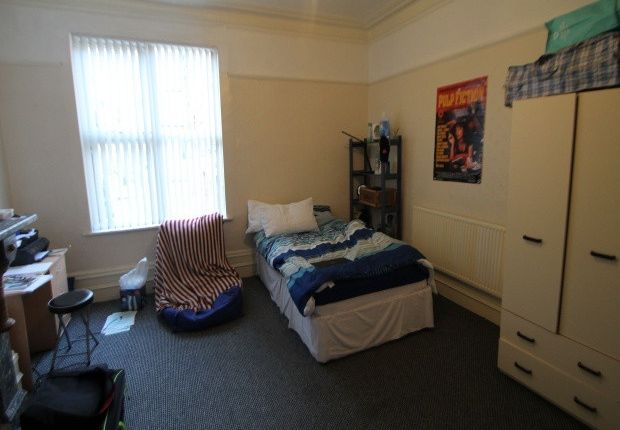 A Cozy Bedroom Featuring A Single Bed, A Wardrobe,...