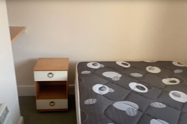 A Cozy Bedroom Featuring A Neatly Made Bed With A ...