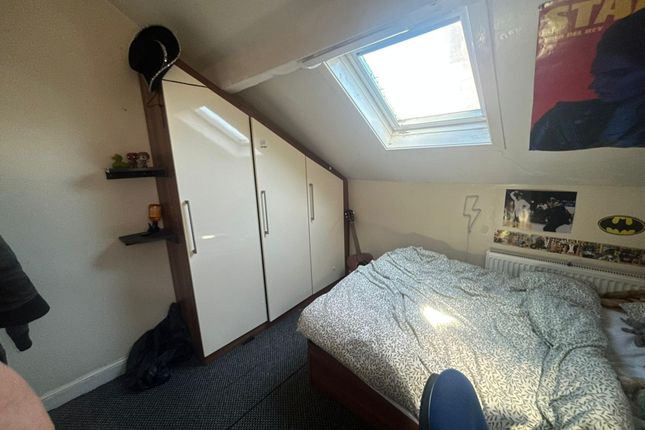 A Cozy Bedroom Featuring A Bed, Wardrobe, And A Sk...