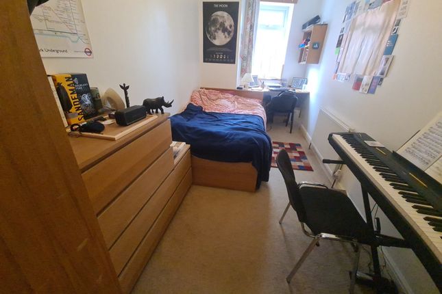 A Cozy Single Bedroom Featuring A Comfortable Bed,...