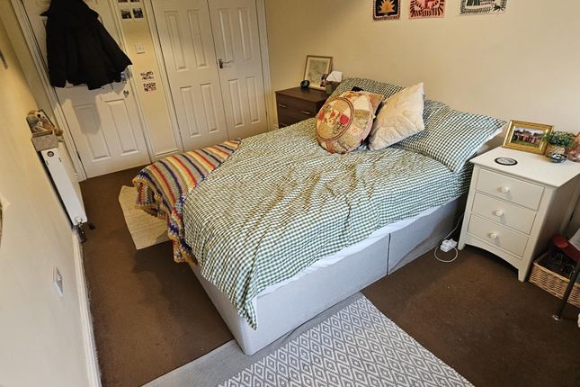 A Cozy Single Bedroom Featuring A Well-Made Bed Wi...