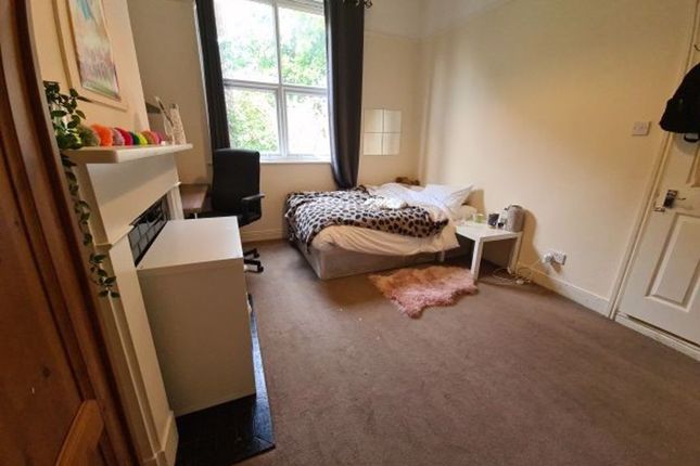 A Cozy Single Bedroom Featuring A Large Window Wit...