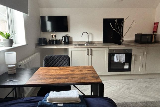 This Modern Kitchen Area Features Sleek Cabinetry,...