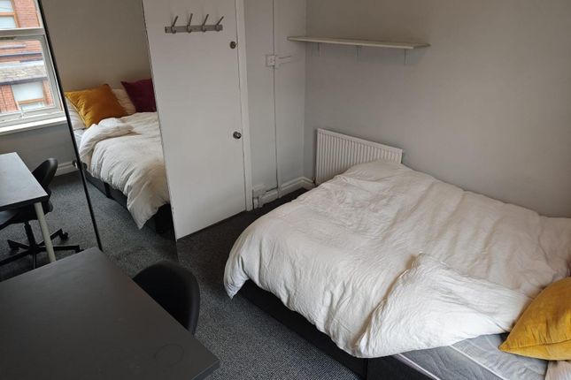 A Bright And Tidy Single Bedroom Featuring A Comfo...