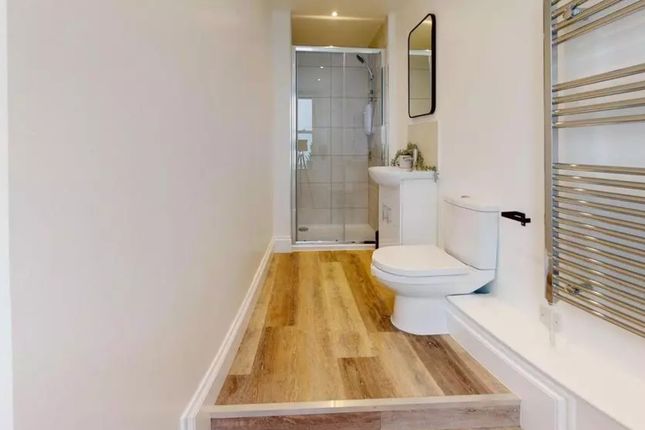 A Modern And Clean Bathroom Featuring A Shower And...