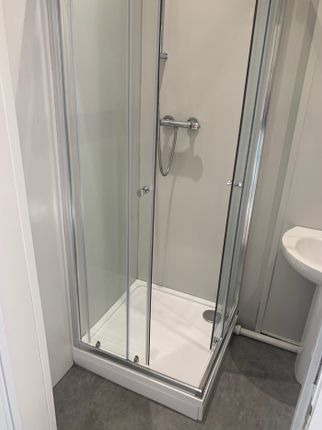 Modern Shower Area Featuring Sleek Glass Doors And...
