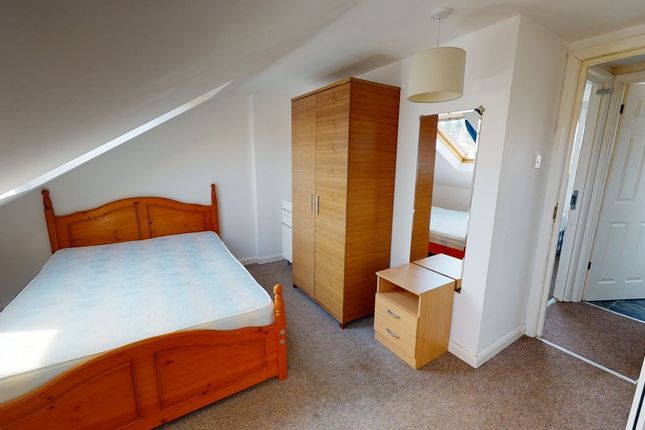 A Cozy Bedroom Featuring A Double Bed With A Woode...