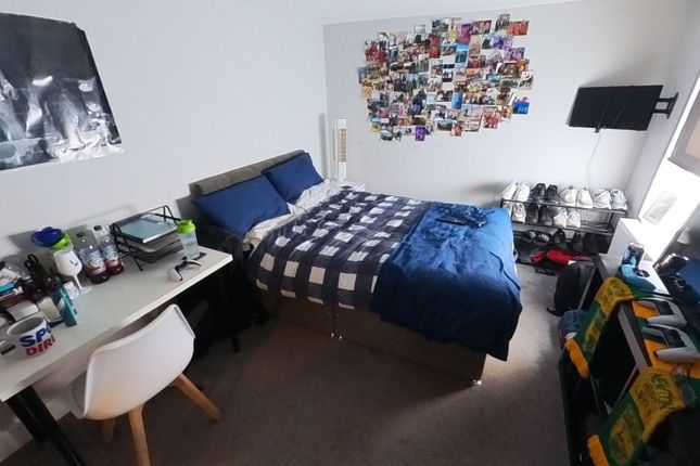 A Cozy Bedroom Featuring A Single Bed, A Study Des...