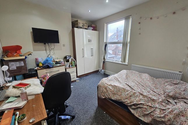 A Cozy Bedroom Featuring A Bed With A Patterned Be...