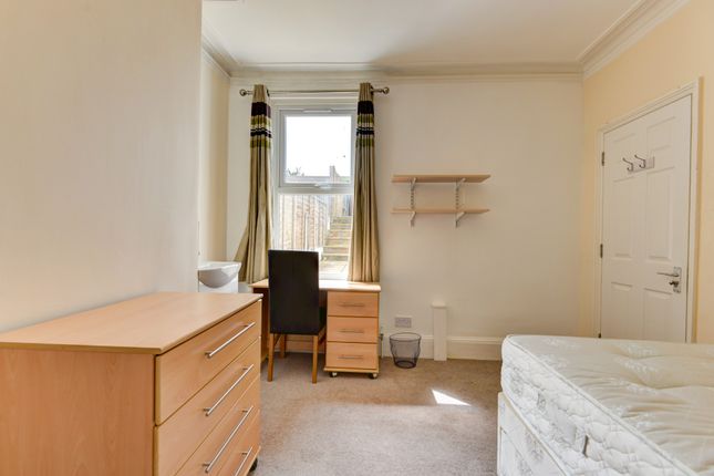 A Bright And Tidy Bedroom Featuring A Bed, A Windo...