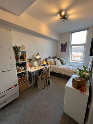 A Cozy Single Bedroom Featuring A Bed, A Study Des...